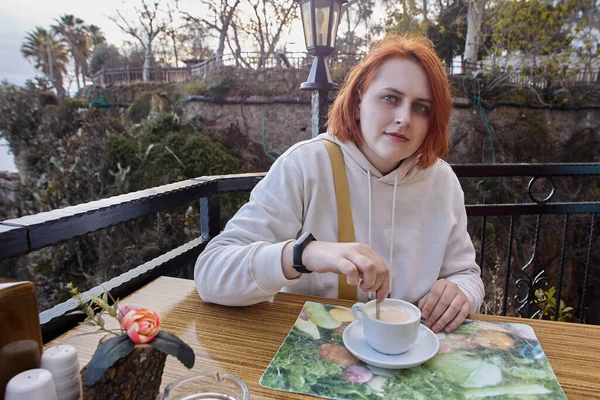 Terras van restaurant aan zee in Antalya, Turkije, jonge Europese roodharige vrouw ontspannen aan tafel met kopje koffie. — Stockfoto