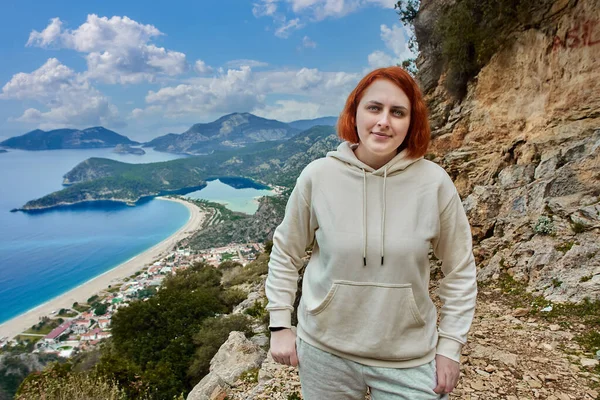 Lycian Trail w Blue Lagoon obszarze miejscowości Oludeniz w pobliżu Fethiye, młoda biała kobieta z czerwonymi włosami stanowi na tle krajobrazu. — Zdjęcie stockowe