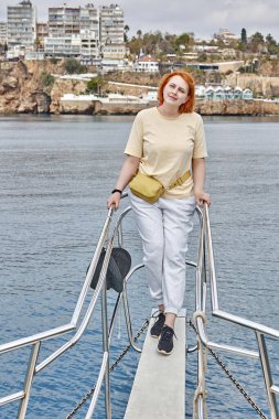 Antalya açıklarında tekne pruvasında fotoğrafçıya poz veren beyaz bir kadınla gezmek..