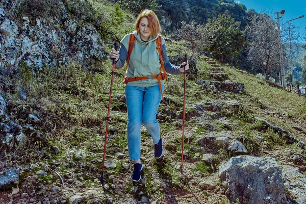 Пешеходные палки помогают молодой женщине пройти через высокогорье. — стоковое фото