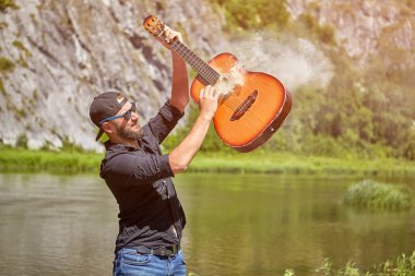 Çılgın gitarist Forest River yakınlarında sigara içiyor..