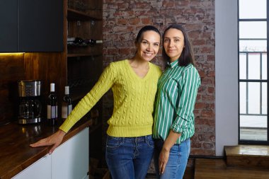 İki beyaz kız kardeşin aile fotoğrafı, narin olgun kadınlar, çatı katında poz veriyorlar..