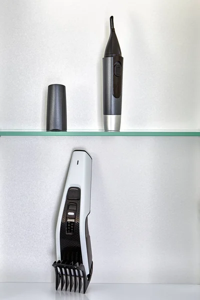 Hairclipper a kosmetické trimmer na polici v koupelně skříň. — Stock fotografie