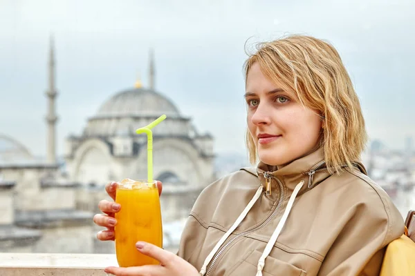 Jovem segurando vidro de suco na frente da mesquita fora da janela. — Fotografia de Stock