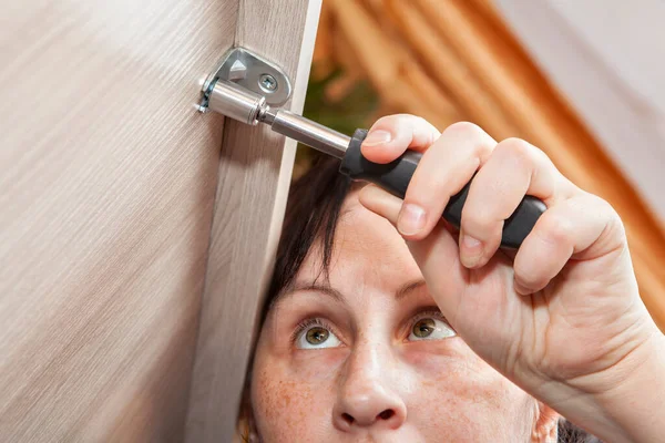 Self assembly of furniture from flat packing, woman tightens fastening nut. — Stock Photo, Image