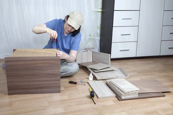 Montaje DIY de muebles de paquete plano, tornillo de fijación atornillado mujer madura. — Foto de Stock