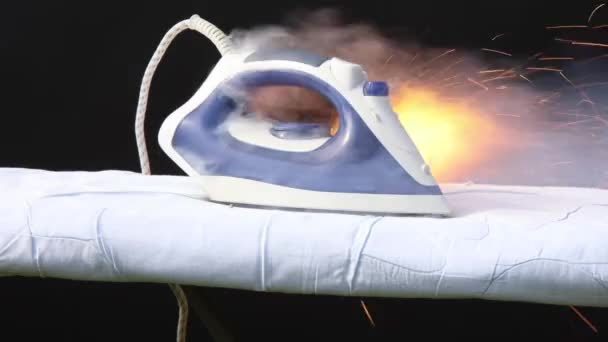 Clothes iron has overheated and caught fire on ironing board, faulty household appliance is burn. — Stock Video