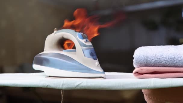 Clothes iron caught fire on an ironing board, faulty home appliance is burn. — Stock Video