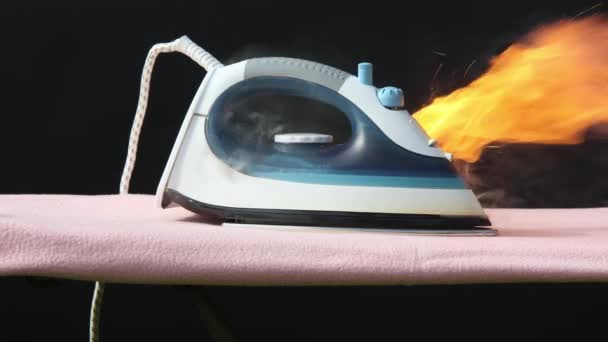 Faulty home appliance is burn, an iron for clothes has caught fire on ironing board. — Stock Video