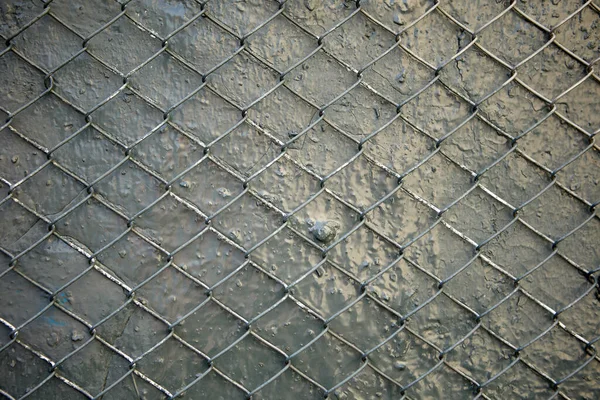 Gri boyanmış duvarın dokusu çelik tel örgüyle güçlendirilmiş..