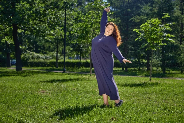 而且体形肥胖的女人在公园的草坪上跳舞. — 图库照片
