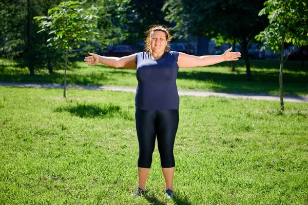 Obeso mulher europeia fazendo exercícios matinais na natureza. — Fotografia de Stock