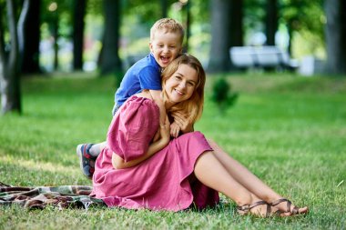 Neşeli küçük çocuk. 3 yaşında, annesine sarılmış..