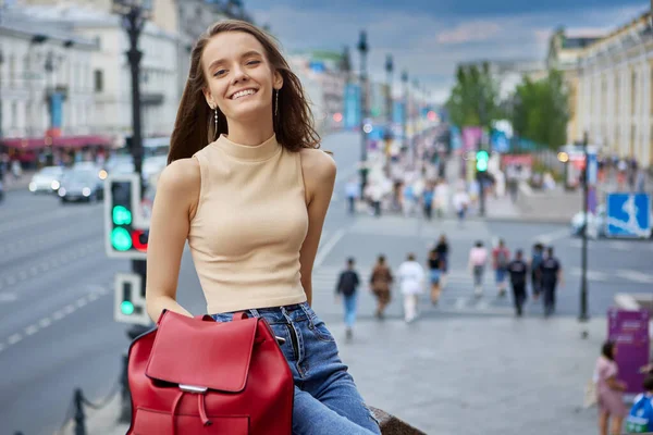 Glimlachende slanke Europese vrouw 18 jaar oud rust 's avonds op straat. — Stockfoto