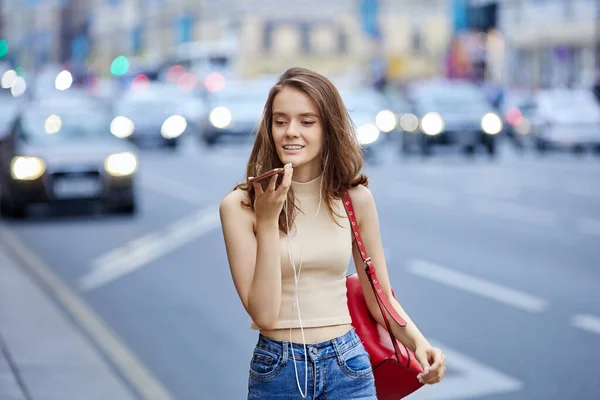 Mulher bonita está usando smartphone para falar online ao ar livre. — Fotografia de Stock