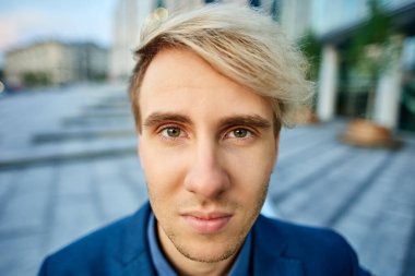 Ciddi görünümlü genç sarışın bir adam..