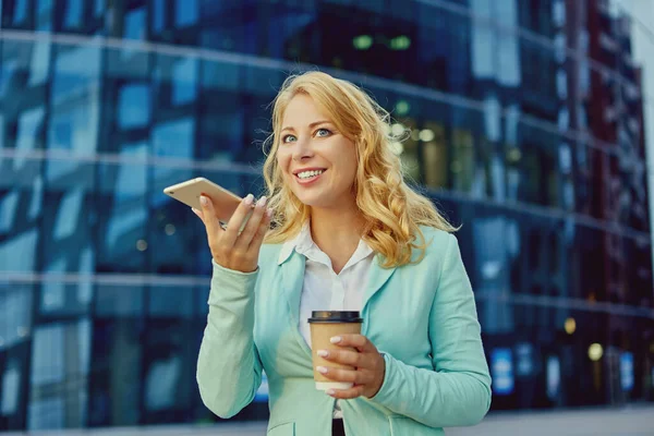 若い女性は携帯電話で話し、外のコーヒーを飲む. — ストック写真