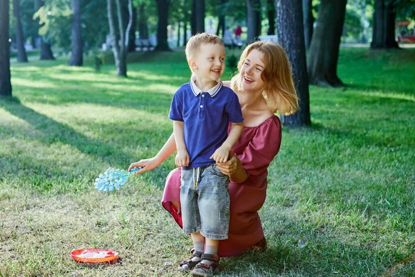 Smiling mother and little son walks outdoors together. — Stock Photo, Image