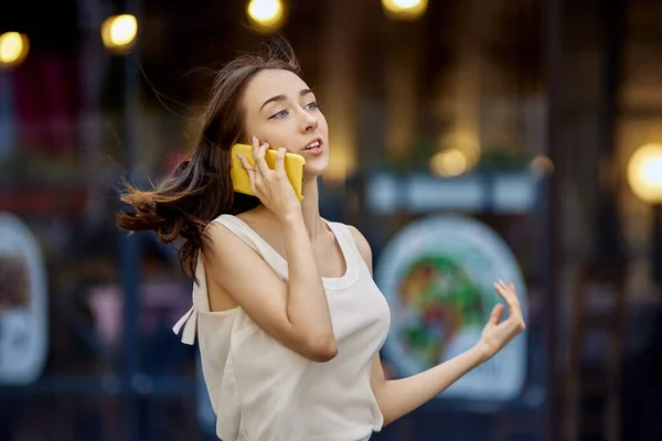Slim nastolatek dziewczyna mówi przez smartfona na ulicy miasta. — Zdjęcie stockowe