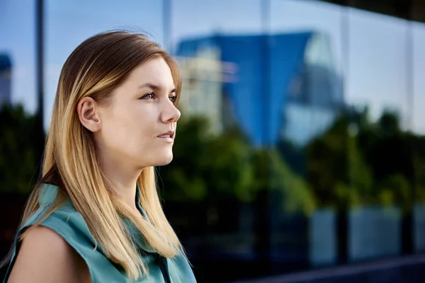 Seriös ung dam står utanför nära glasvägg. — Stockfoto