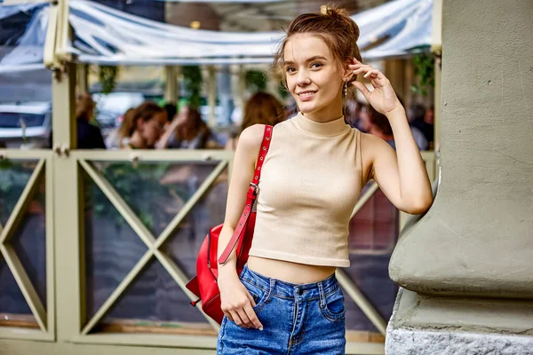 Gelukkige jonge dame staat tijdens het wandelen en glimlacht. — Stockfoto