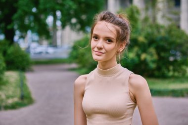 Gerçekten zarif bir bayan yazın şehir bahçesinde duruyor..