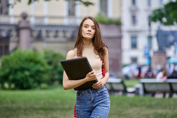 Serious elegant woman with laptop in hands outside. — Stock Photo, Image