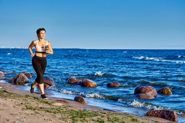 アクティブな優雅な女性は夏に海岸近くを走る. — ストック写真