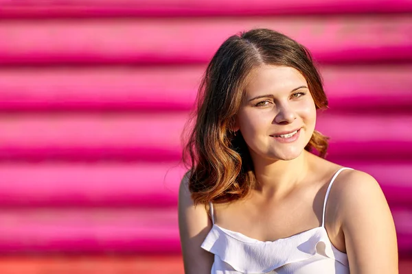 Smiling young white brunette woman over pink background. — Stock Photo, Image