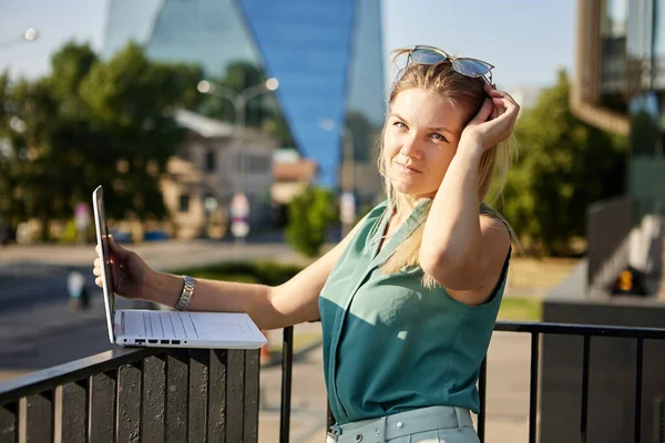 Jonge vrouw gebruikt laptop voor werk op afstand. Stockafbeelding