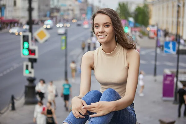 Gelukkig jonge vrouw zit in het centrum van de stad tijdens het lopen. — Stockfoto