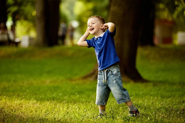 Criança pequena feliz no jardim da cidade no verão. — Fotografia de Stock