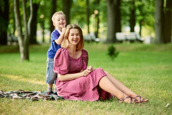 Smiling mother with little boy walk in public park. — Stock Photo, Image