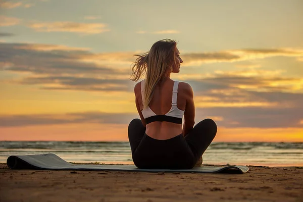 Ejercicios de yoga al atardecer por mujer caucásica. — Foto de Stock