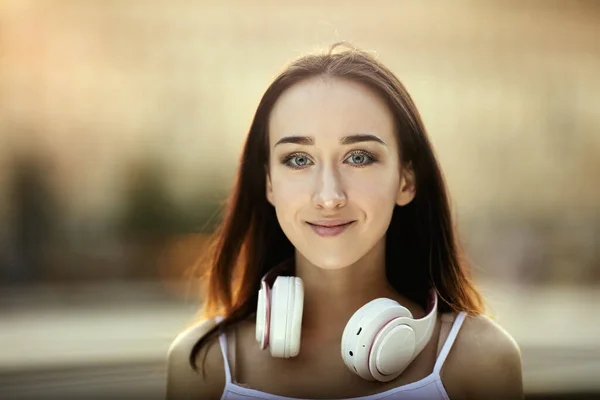 Biała kobieta ze słuchawkami bezprzewodowymi w ciągu dnia. — Zdjęcie stockowe