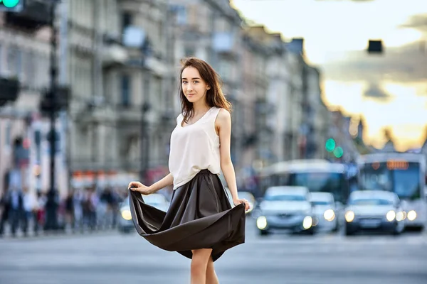Slim woman stands on street near traffic at daytime. — Stock Photo, Image