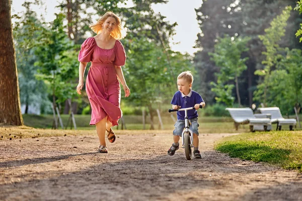 Mother and boy 3 years old on bicycle in park. — Stock Photo, Image