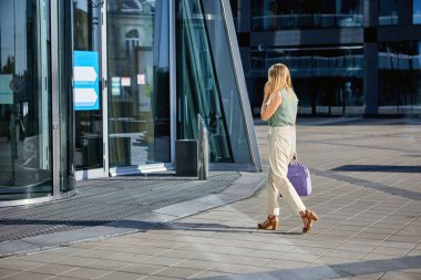 İş kadını işe gider ve telefonla konuşur..