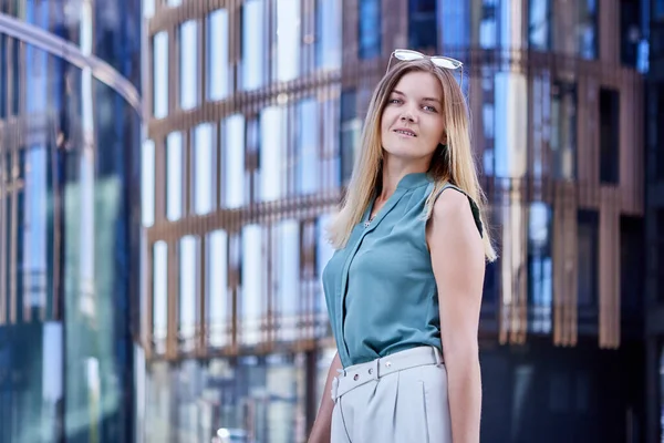 Молода бізнес-леді в костюмі стоїть біля офісної будівлі . — стокове фото