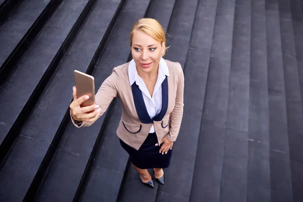 Woman in suit makes video call by phone outside. — Stock Photo, Image