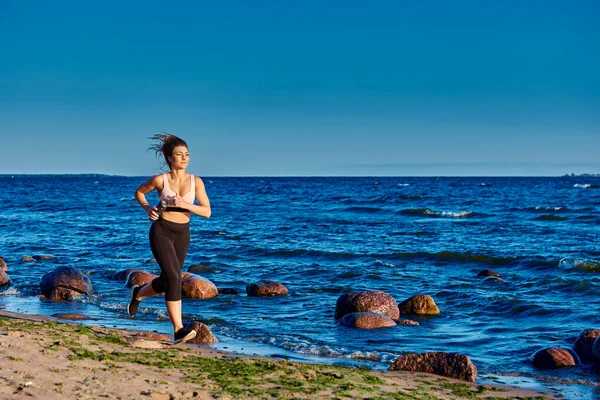 Woman is running near seaside at summer morning. — Stock Photo, Image