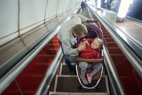在地下自动扶梯上与父亲一起行走的儿童. — 图库照片