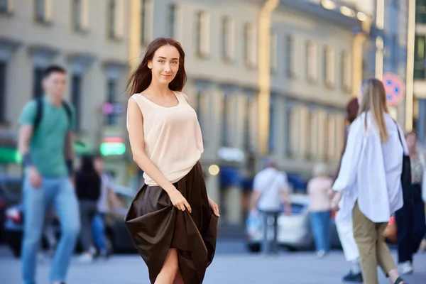 Glimlachende jonge vrouw loopt op straat. — Stockfoto