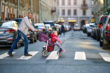 Baba, çocuğu yaya geçidinde bir gezintiye çıkarıyor..