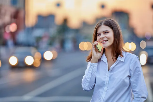 若い女性は交通近くのスマートフォンで話す. — ストック写真