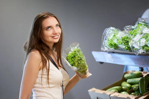 Caucásico cliente femenino sostiene ensalada en supermercado. — Foto de Stock