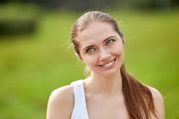 Mulher alegre caucasiana fica no parque durante o dia. — Fotografia de Stock