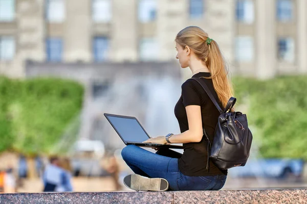 Fernarbeit einer Frau mit Laptop im Stadtgarten. — Stockfoto