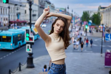 İnce bir kadın. 18 yaşında. Yaz akşamının kalabalık caddesinde..