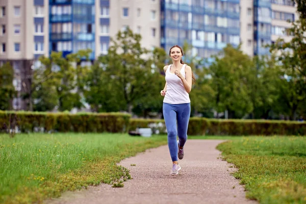 Woman in her 20s jogging in multi storey area. — Stock Photo, Image